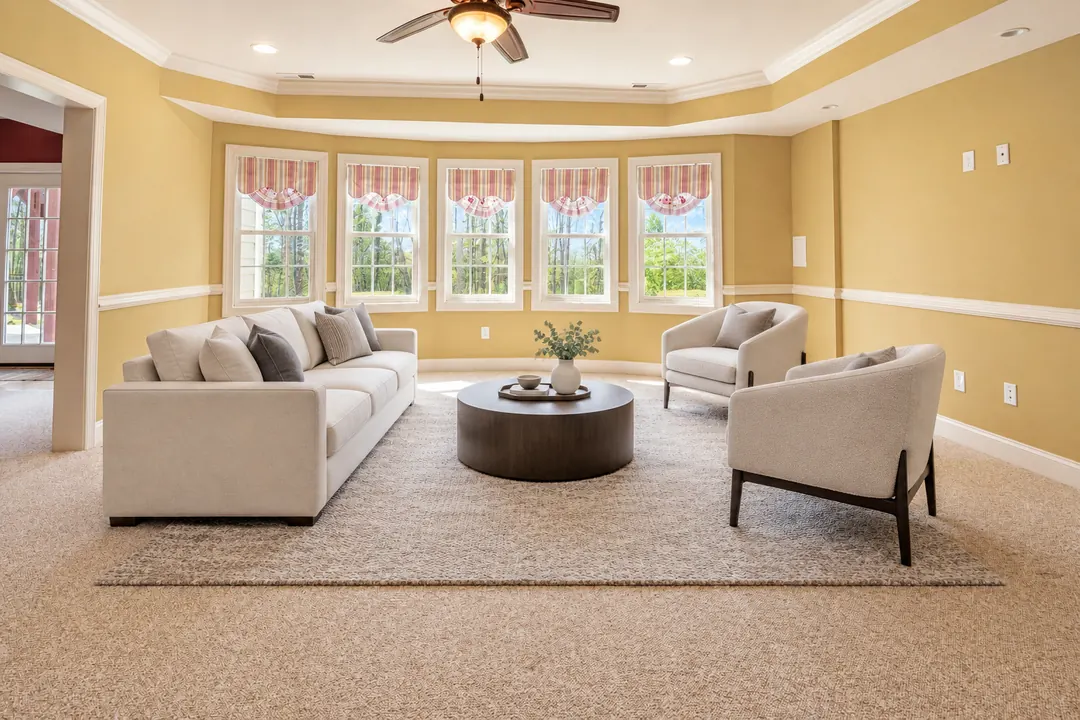 A living room virtually staged by Lumo with a sofa, two armchairs, a rug and a round coffee table